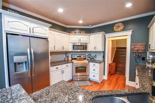4742 Thunder River Dr, Gainesville, GA 30506 - kitchen featuring appliances with stainless steel finishes, light wood-style floors, white cabinetry, backsplash, and dark stone counters