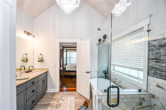 4742 Thunder River Dr, Gainesville, GA 30506 - bathroom featuring a chandelier, double vanity, a soaking tub, wood finished floors, and a stall shower
