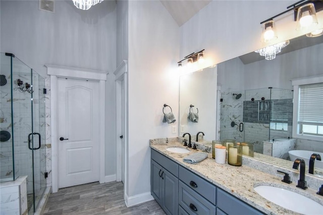4742 Thunder River Dr, Gainesville, GA 30506 - full bathroom with a shower stall, double vanity, a soaking tub, wood finished floors, and a chandelier