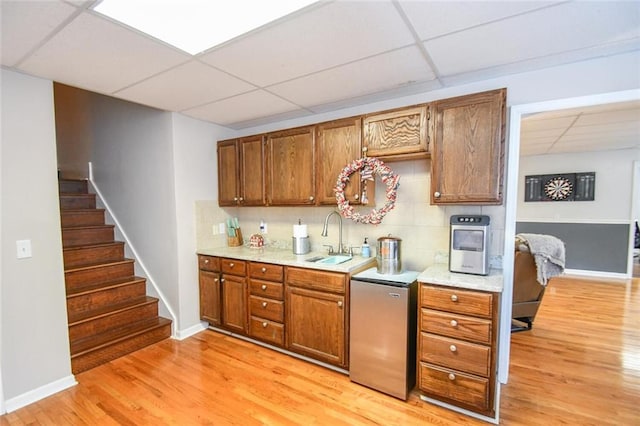 4742 Thunder River Dr, Gainesville, GA 30506 - kitchen featuring a drop ceiling, fridge, light wood-style floors, brown cabinetry, and decorative backsplash