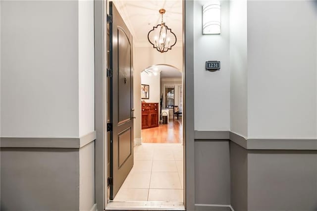 corridor with a chandelier and light tile patterned floors