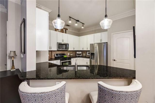 kitchen featuring tasteful backsplash, dark stone counters, stainless steel appliances, white cabinets, and hanging light fixtures