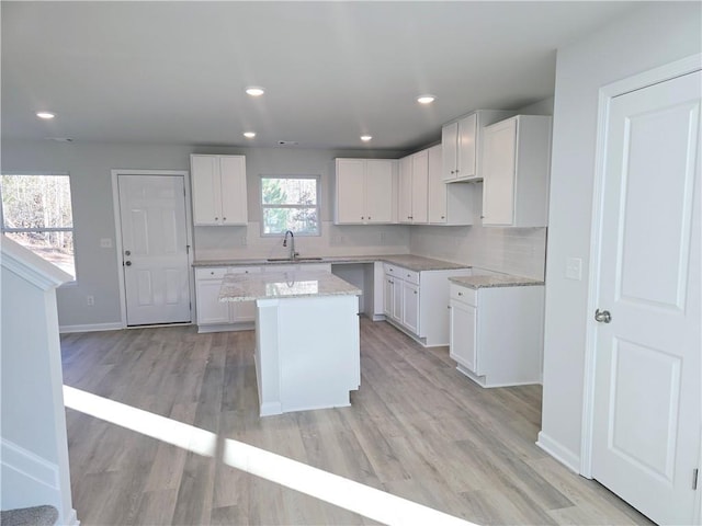 kitchen featuring a center island, sink, and white cabinets