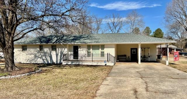 ranch-style house with a carport and a front lawn