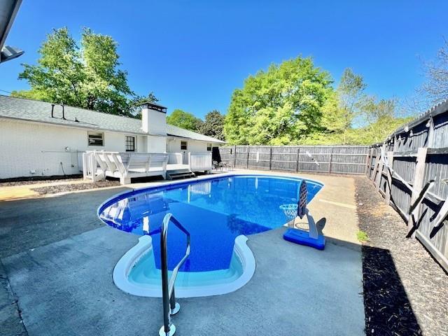 view of pool with a fenced in pool, a fenced backyard, and a wooden deck
