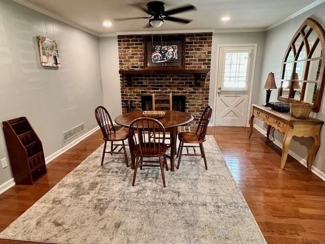 dining area with crown molding, wood finished floors, and visible vents