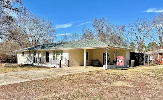 exterior space with a carport and a lawn