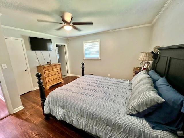 bedroom with dark wood-style floors, ceiling fan, baseboards, and ornamental molding