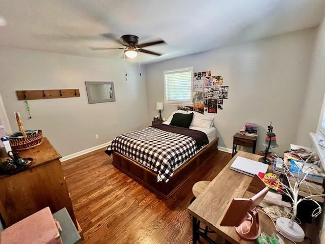 bedroom featuring a ceiling fan, baseboards, and wood finished floors