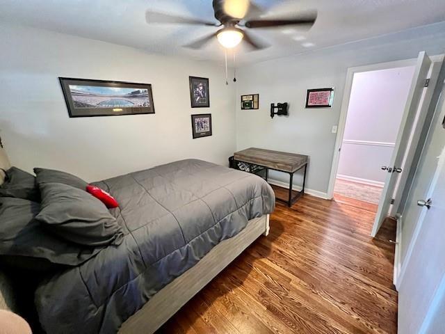 bedroom featuring ceiling fan, baseboards, and wood finished floors