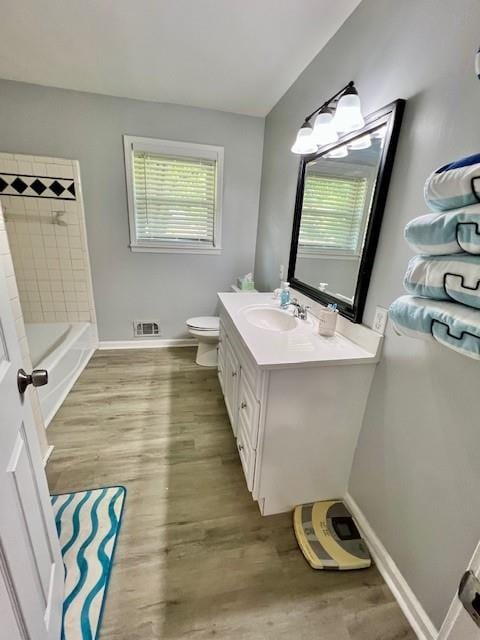 bathroom with visible vents, baseboards, a healthy amount of sunlight, and wood finished floors