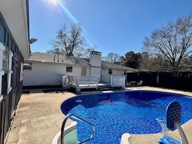 view of pool with a patio area, a fenced in pool, a deck, and fence