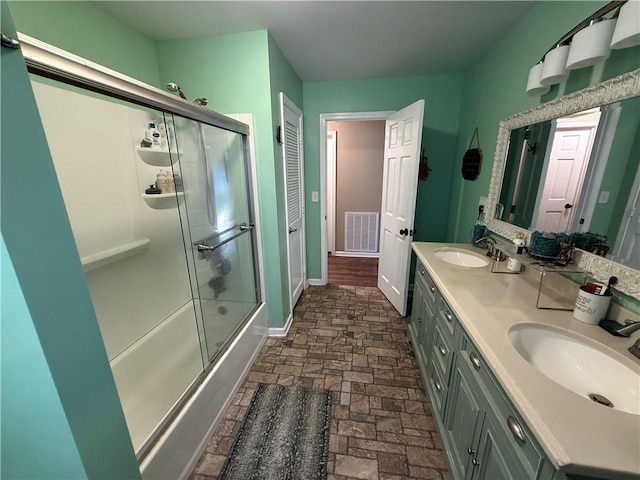 222 Akin Rd, Martin, GA 30557 - bathroom with double vanity, bath / shower combo with glass door, brick flooring, and baseboards
