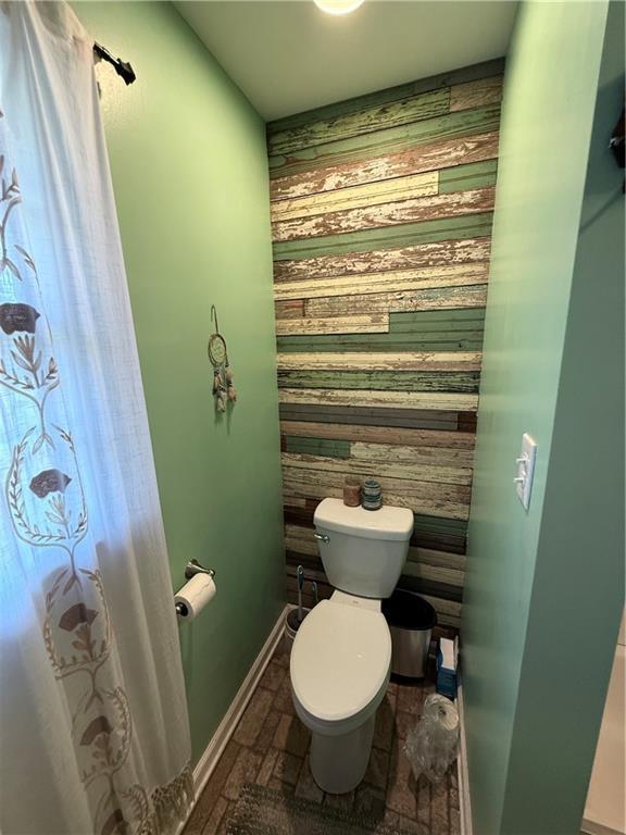 222 Akin Rd, Martin, GA 30557 - bathroom with toilet, wood walls, and baseboards