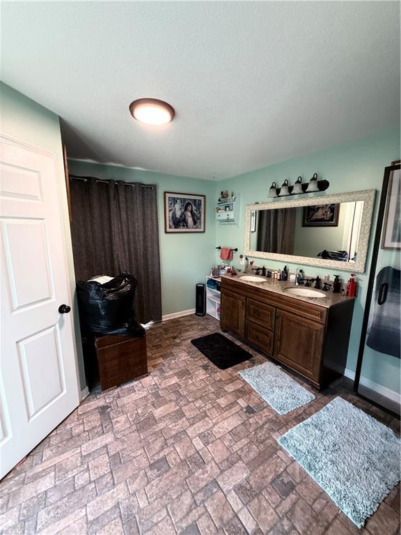 222 Akin Rd, Martin, GA 30557 - full bathroom with brick patterned flooring, double vanity, baseboards, and a shower
