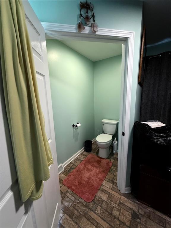 222 Akin Rd, Martin, GA 30557 - bathroom featuring toilet, brick flooring, and baseboards