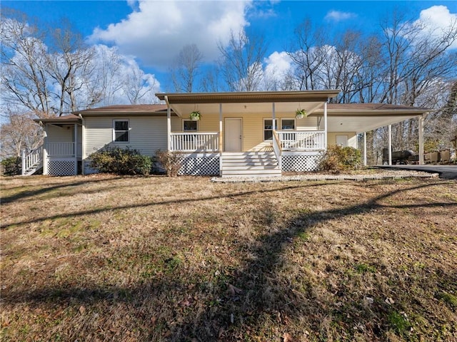 view of front of house with a front lawn, a carport, and covered porch