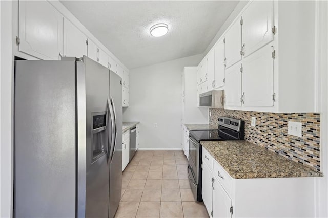 kitchen featuring a textured ceiling, light tile patterned flooring, stainless steel appliances, white cabinets, and tasteful backsplash