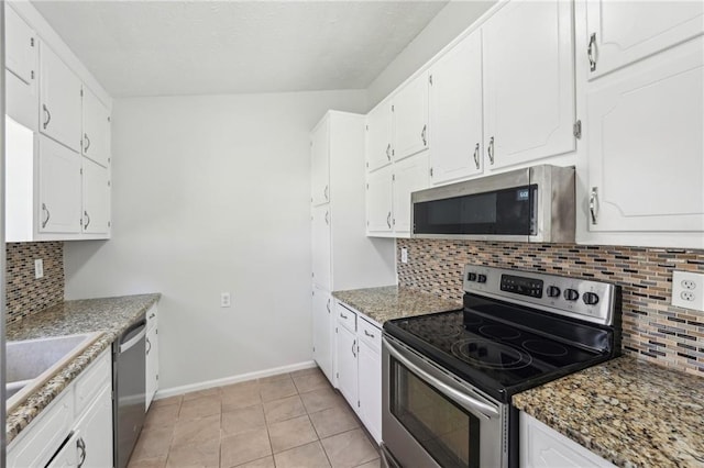 kitchen with stainless steel appliances, decorative backsplash, white cabinetry, light tile patterned flooring, and baseboards