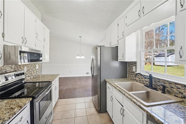 kitchen with appliances with stainless steel finishes, a sink, and white cabinetry