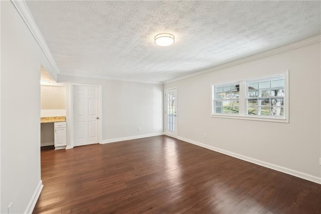 spare room featuring baseboards, a textured ceiling, ornamental molding, and dark wood-style flooring