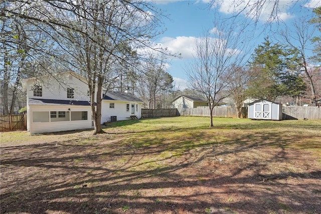 view of yard featuring a shed, an outdoor structure, and a fenced backyard