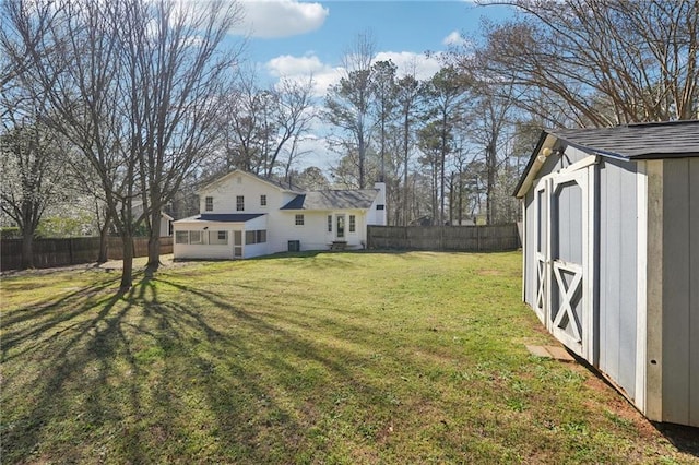 view of yard with a fenced backyard, a storage unit, and an outdoor structure