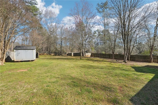 view of yard featuring a fenced backyard, a storage unit, and an outdoor structure