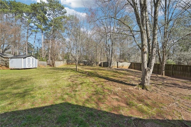 view of yard with an outdoor structure, fence, and a storage shed