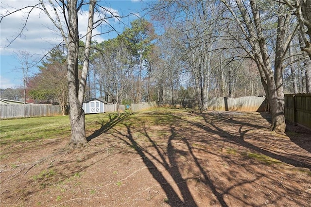 view of yard with a fenced backyard, an outdoor structure, and a storage unit