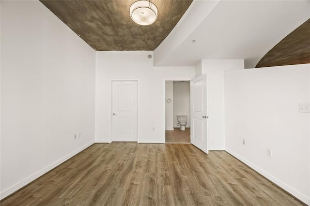 unfurnished bedroom with wood finished floors and baseboards
