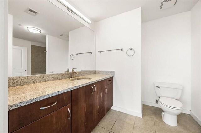 full bath with tile patterned flooring, baseboards, toilet, and vanity