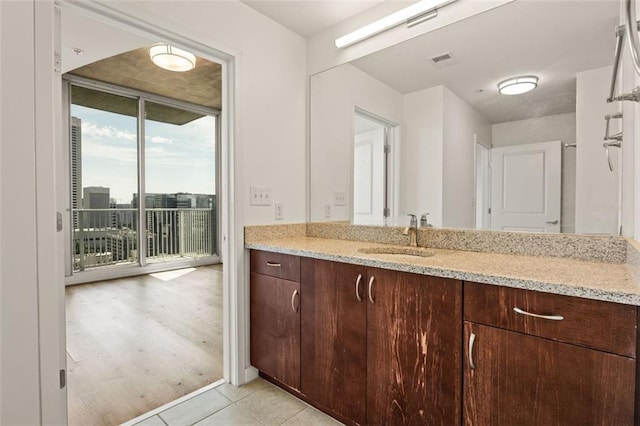 bathroom featuring expansive windows, vanity, and tile patterned flooring