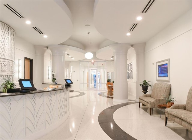 reception area featuring ornate columns and recessed lighting