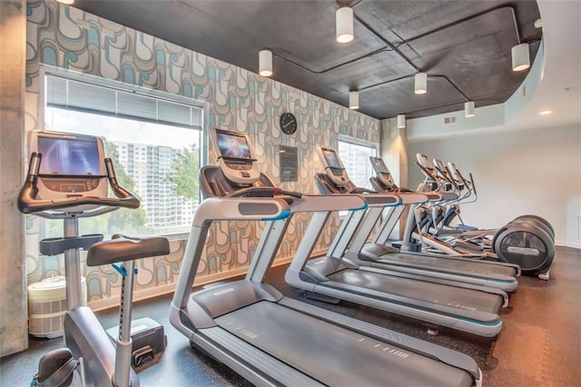 exercise room with wallpapered walls and baseboards