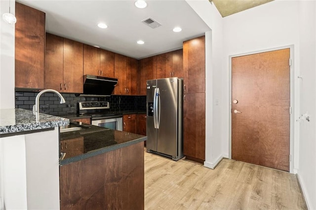 kitchen featuring appliances with stainless steel finishes, light wood finished floors, decorative backsplash, recessed lighting, and baseboards