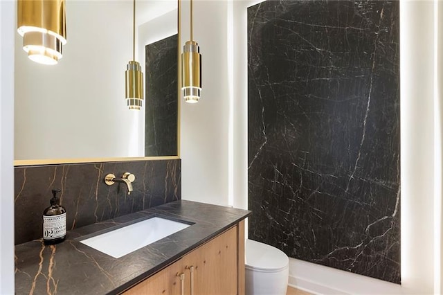 bathroom featuring backsplash, vanity, and toilet