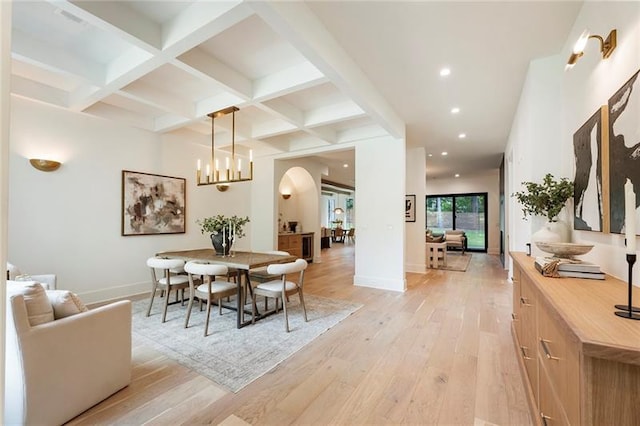 dining area featuring beamed ceiling, light hardwood / wood-style flooring, and coffered ceiling