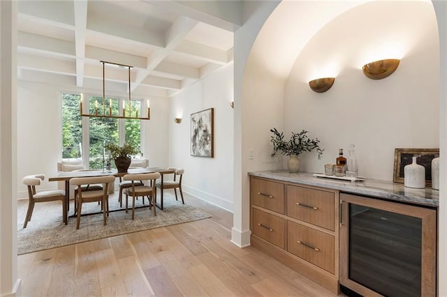 bar featuring beam ceiling, light hardwood / wood-style flooring, beverage cooler, and coffered ceiling