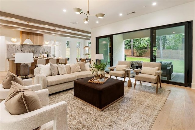 living room featuring a notable chandelier and light wood-type flooring