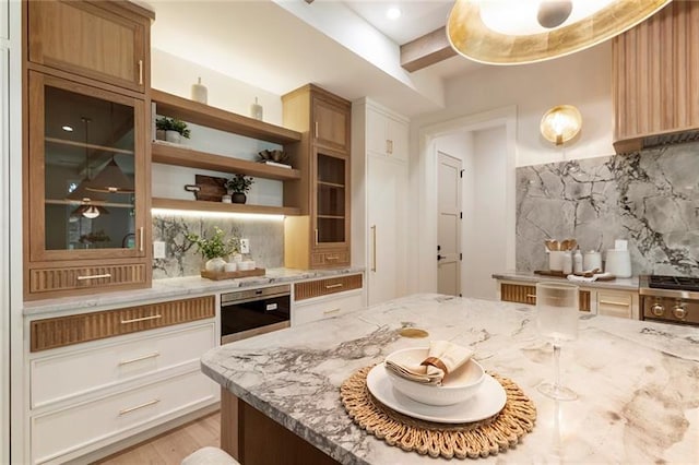 kitchen with white cabinetry, tasteful backsplash, wine cooler, light stone counters, and light wood-type flooring