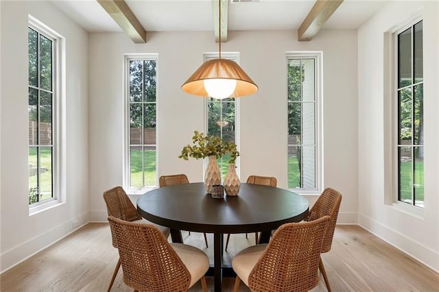 dining area featuring beamed ceiling and light wood-type flooring