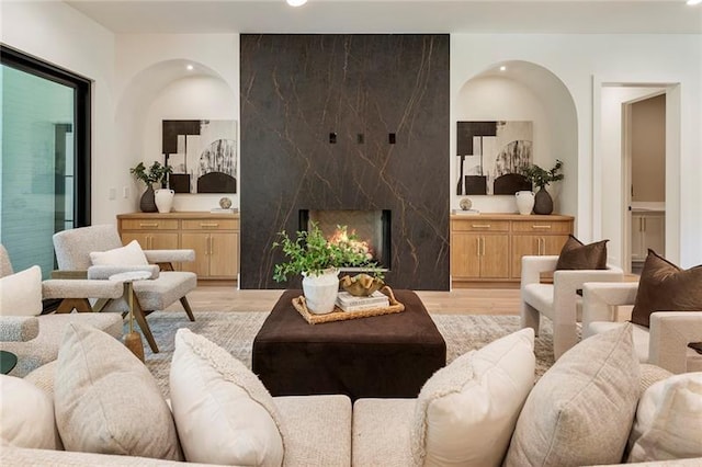 living room featuring light wood-type flooring and a fireplace