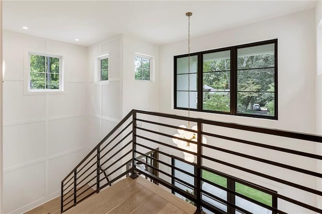 stairway featuring hardwood / wood-style floors and a healthy amount of sunlight