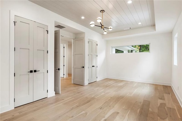 unfurnished room featuring wooden ceiling, light hardwood / wood-style floors, and a notable chandelier