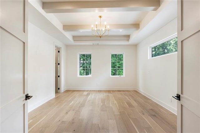 empty room with light hardwood / wood-style flooring, a wealth of natural light, and a notable chandelier