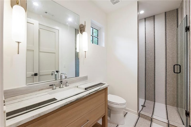 bathroom with tile patterned floors, vanity, toilet, and a shower with door