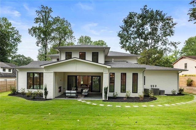 rear view of house featuring outdoor lounge area, cooling unit, a patio area, and a yard