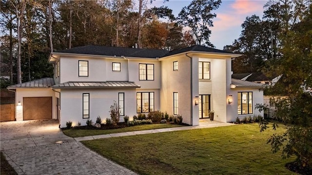 view of front of house with a garage and a yard