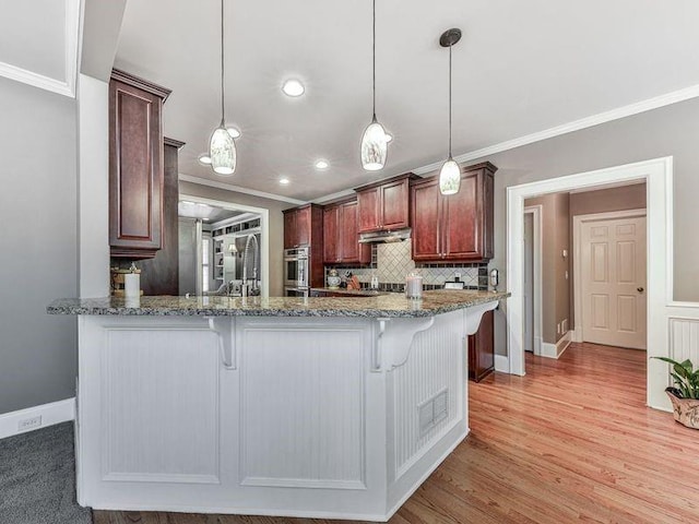 535 Crested Hawk Rdg, Canton, GA 30114 - kitchen featuring a breakfast bar, crown molding, baseboards, and pendant lighting